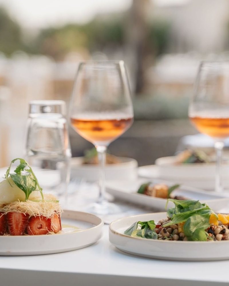 Plated dishes and rosé on a white table